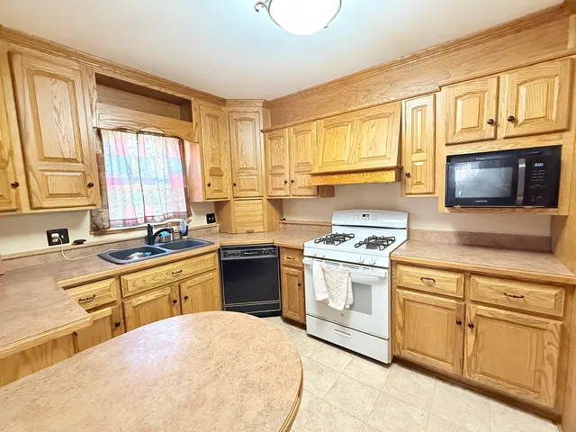 a kitchen with stainless steel appliances granite countertop a stove a sink and a microwave
