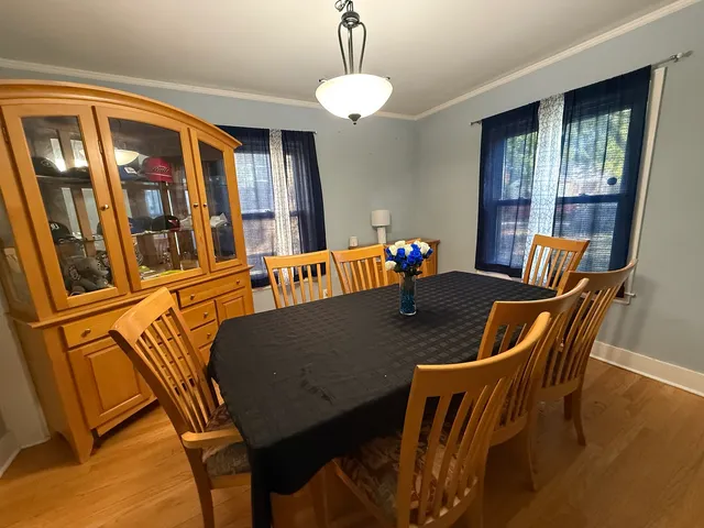 a dining room with furniture a livingroom view and wooden floor