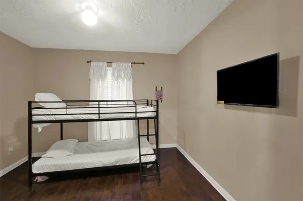 a bedroom with a bed and a flat screen tv