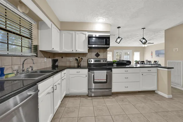 a kitchen with stainless steel appliances granite countertop a sink and cabinets