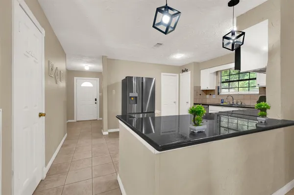 a kitchen with stainless steel appliances granite countertop a sink and a refrigerator