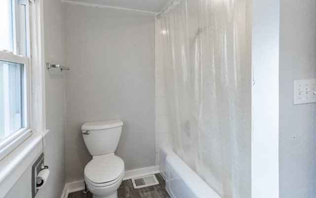 407 Maple Street Marengo, IL 60152 - Photo 19 of 24 a a bathroom with a toilet and a shower curtain
