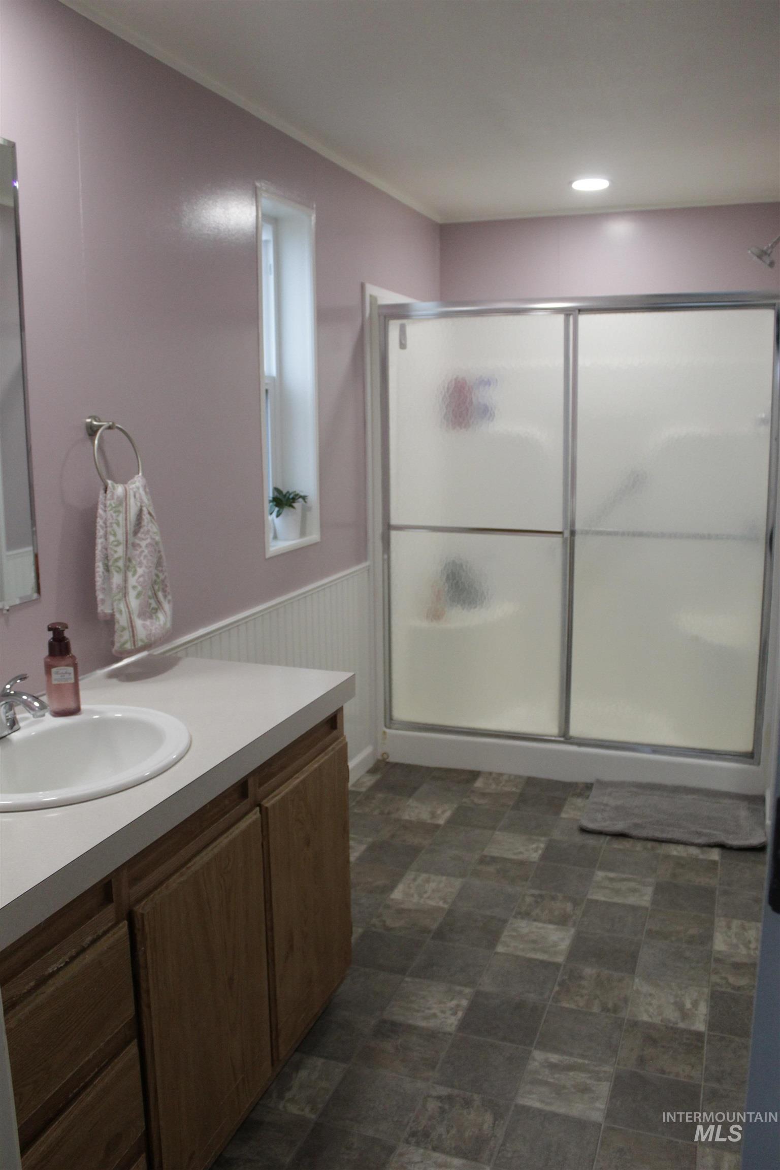 27520 Pearl Road Parma, ID 83660 - Photo 11 of 29 Full bathroom featuring a shower stall, wainscoting, vanity, and crown molding
