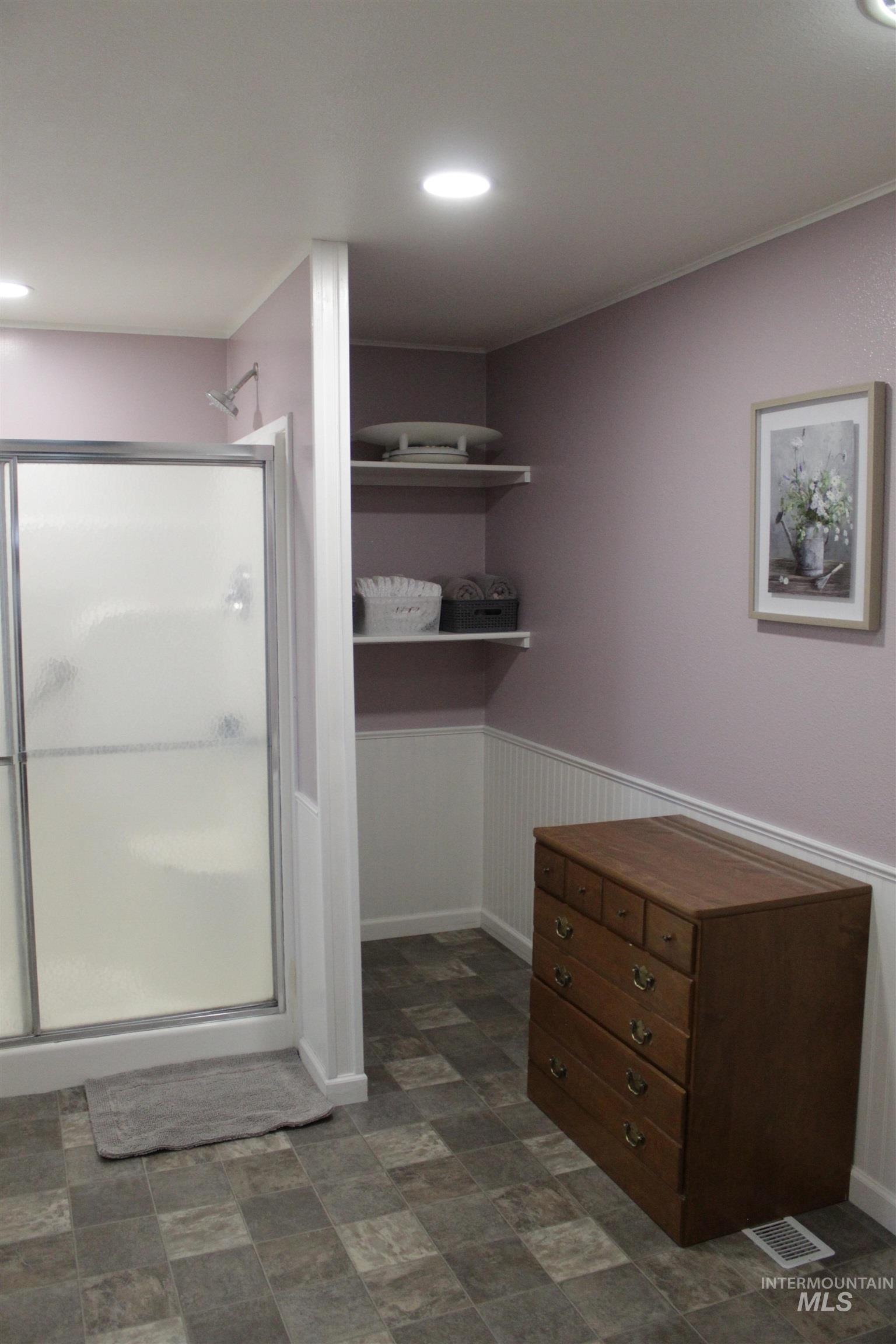 27520 Pearl Road Parma, ID 83660 - Photo 12 of 29 Bathroom featuring a wainscoted wall, a shower stall, and stone finish floors