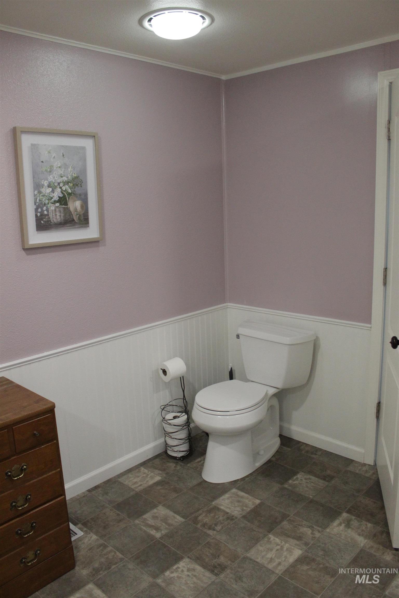 27520 Pearl Road Parma, ID 83660 - Photo 13 of 29 Half bath with stone finish flooring, wainscoting, vanity, and crown molding