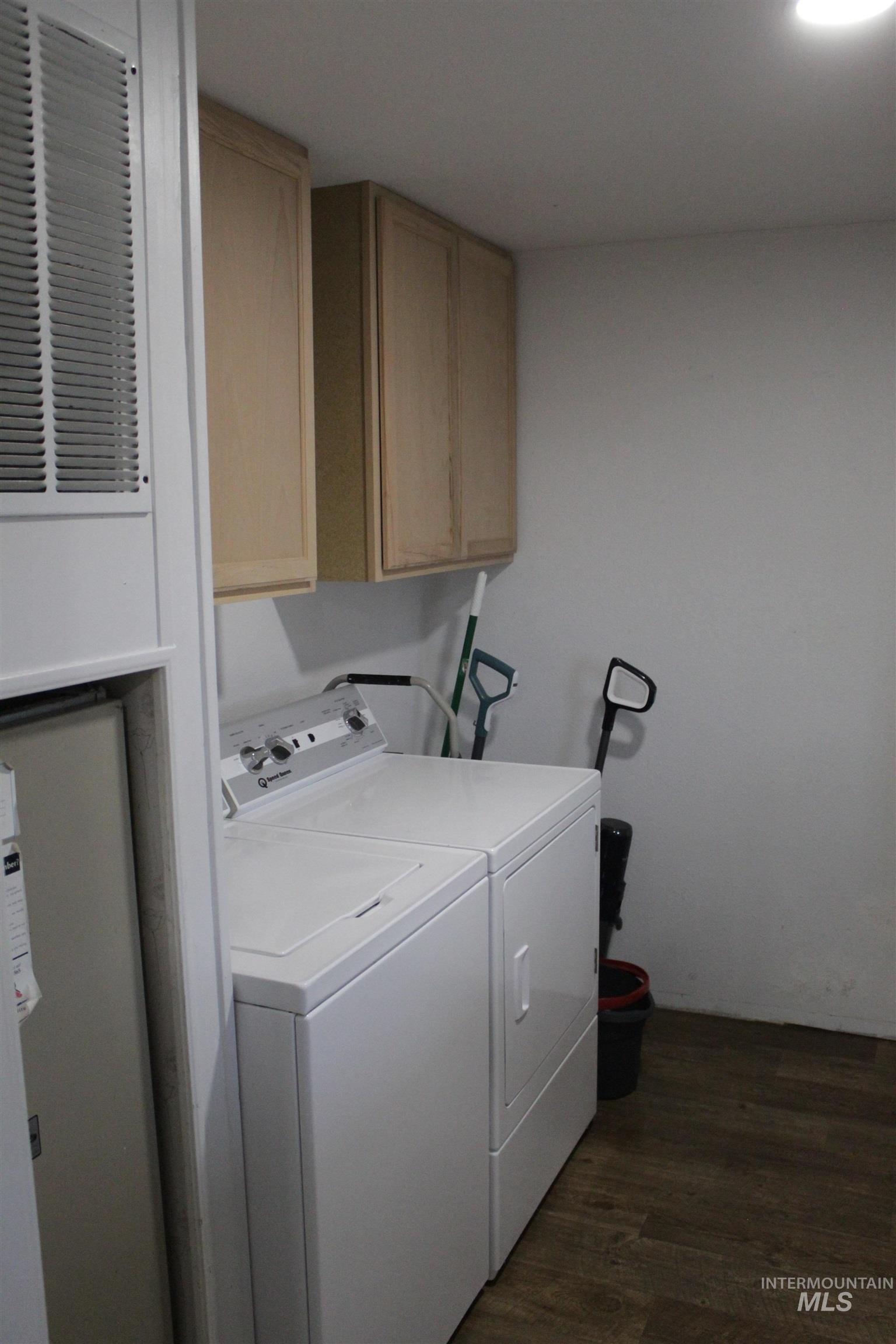 27520 Pearl Road Parma, ID 83660 - Photo 14 of 29 Laundry room featuring dark wood-style floors, cabinet space, a heating unit, and washing machine and clothes dryer