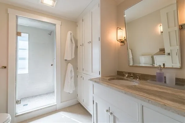a bathroom with a granite countertop sink mirror and shower