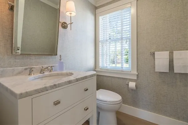 a bathroom with a granite countertop sink toilet and mirror