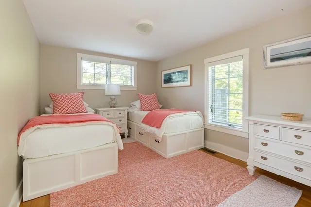 a bedroom with two beds and a dresser