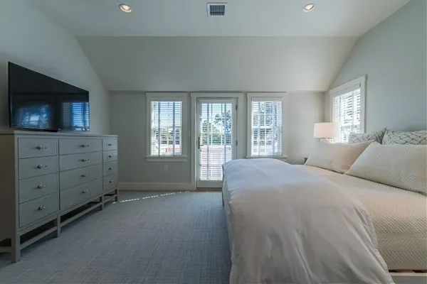 a spacious bedroom with a bed and flat screen tv