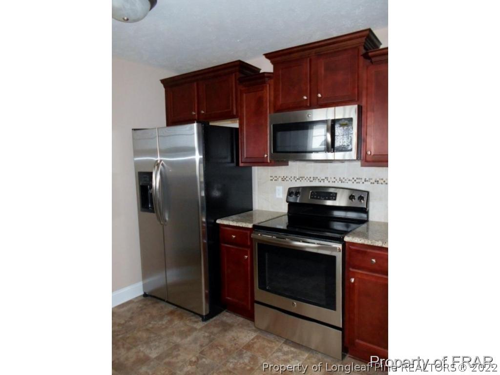 3140 Thrower Road Hope Mills, NC 28348 - Photo 5 of 23 a kitchen with a stove microwave and refrigerator
