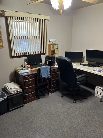 a view of a workspace with furniture and a window