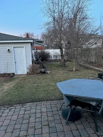 a backyard of a house with barbeque oven table and chairs