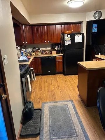 a kitchen with kitchen island granite countertop a refrigerator stove and a sink
