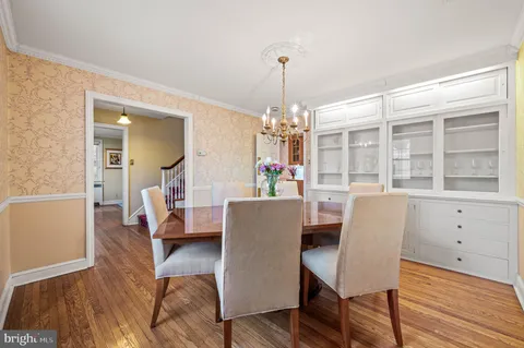 a dining room with furniture a chandelier and wooden floor