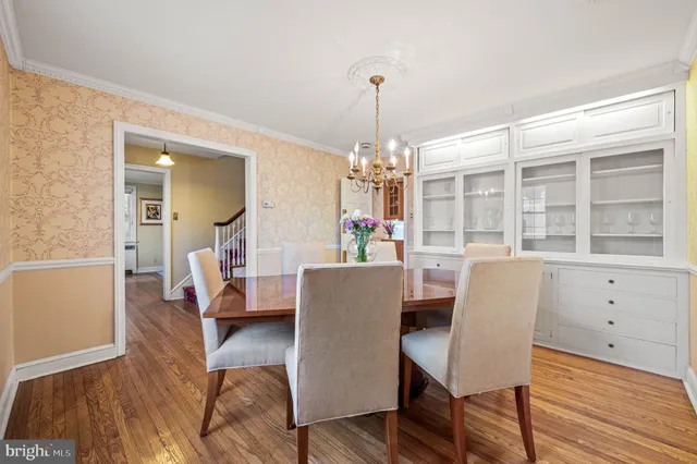 a dining room with furniture a chandelier and wooden floor