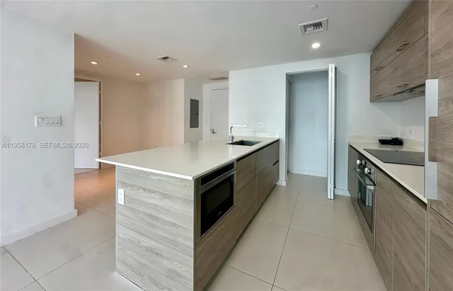 a kitchen with a sink and a stove top oven