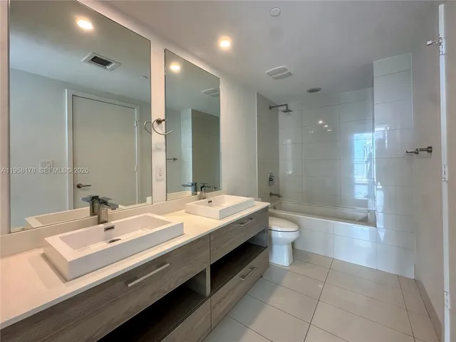 a spacious bathroom with a bathtub shower sink and mirror