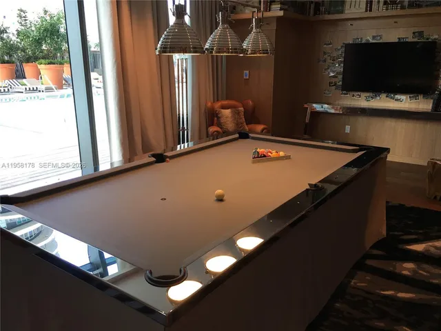 a room with furniture pool table and flat screen tv