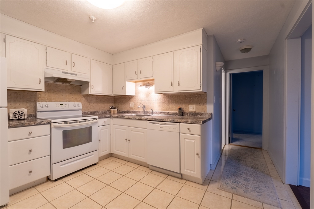 23 Spencer Road, Unit 20F Boxborough, MA 01719 - Photo 1 of 7 a kitchen with granite countertop white cabinets and white appliances