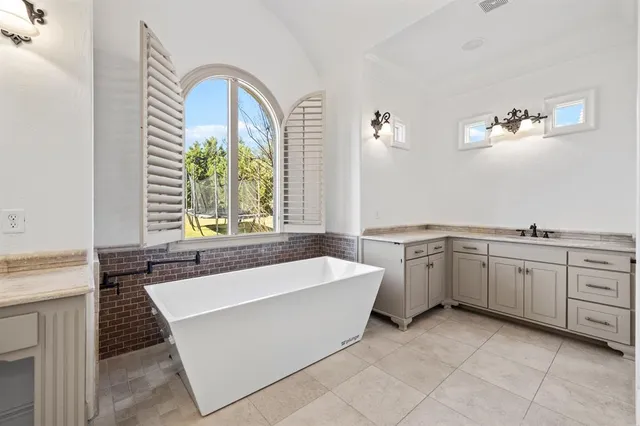 an empty room with wooden floor cabinet and windows