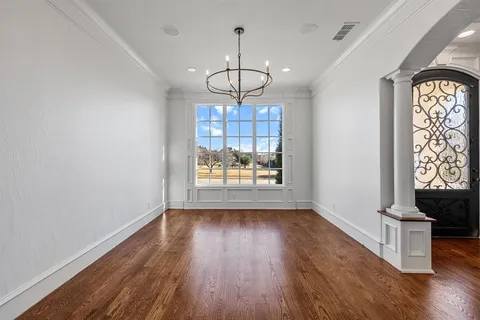 a view of a hallway with wooden floor and a living room