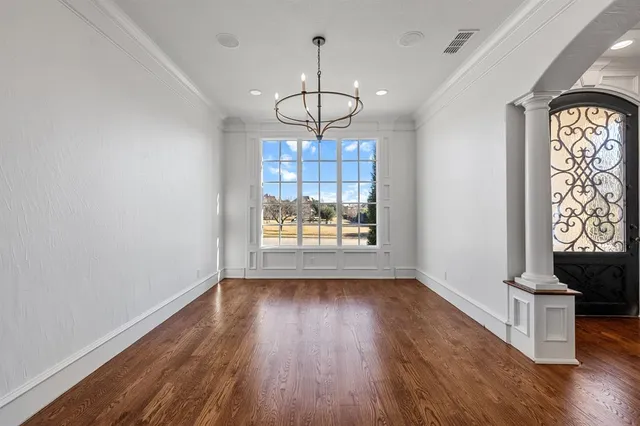 a view of a hallway with wooden floor and a living room