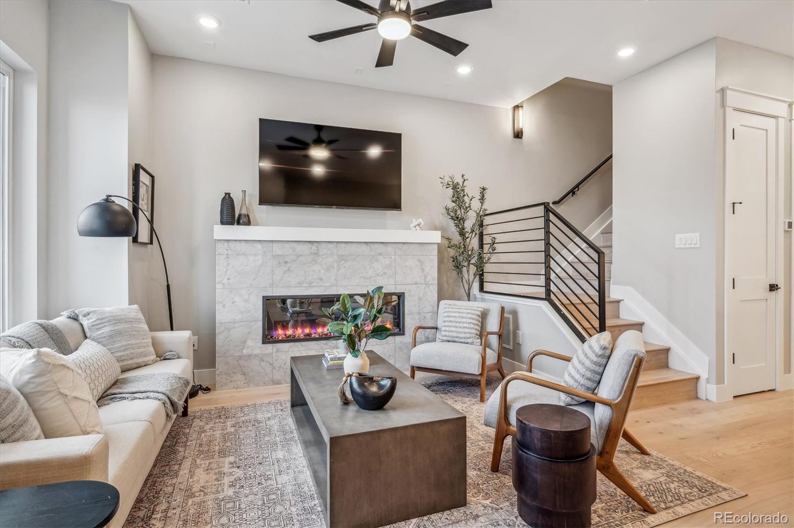 364 East Orchard Road Centennial, CO 80121 - Photo 2 of 30 a living room with furniture a flat screen tv and a fireplace