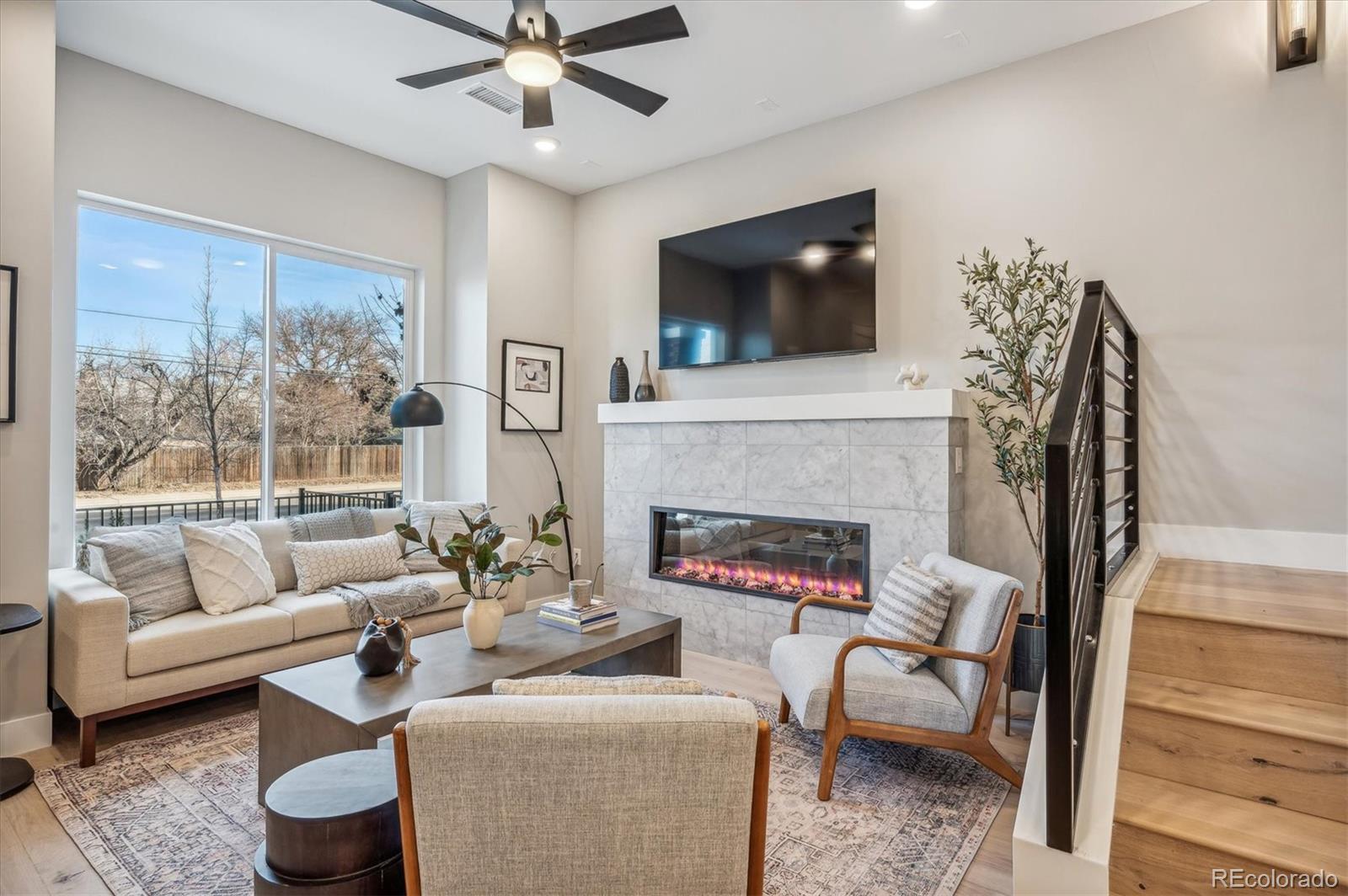364 East Orchard Road Centennial, CO 80121 - Photo 5 of 30 a living room with furniture a flat screen tv and a fireplace