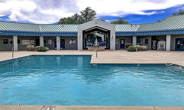 a view of a tennis ground with large trees