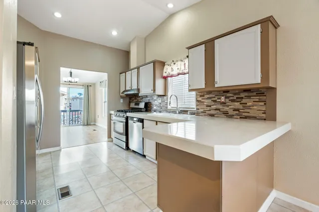 a kitchen with stainless steel appliances a sink and a refrigerator