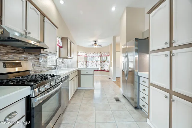 a kitchen with stainless steel appliances granite countertop a stove and a refrigerator