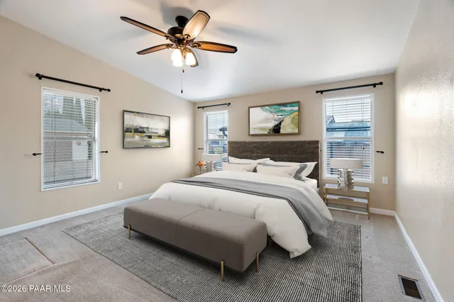 a bedroom with a bed ceiling fan and window