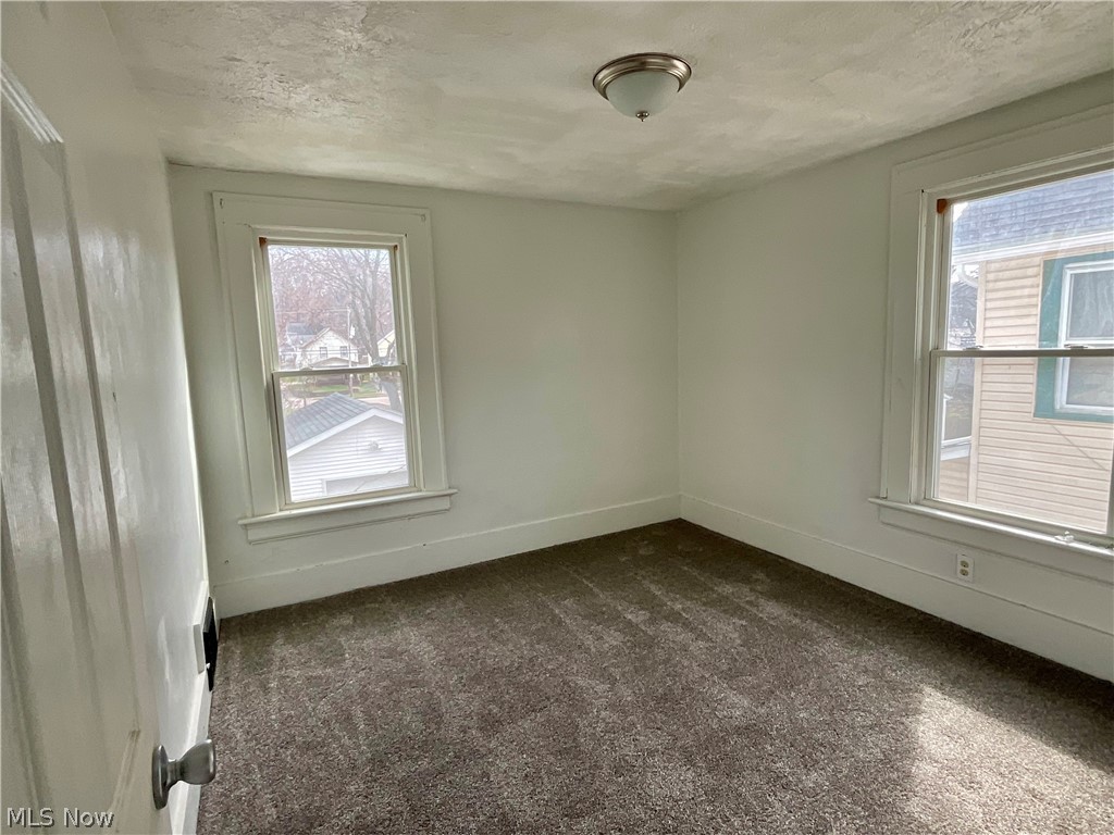 425 Spaulding Street Akron, OH 44310 - Photo 9 of 17 Empty room featuring dark colored carpet and a textured ceiling