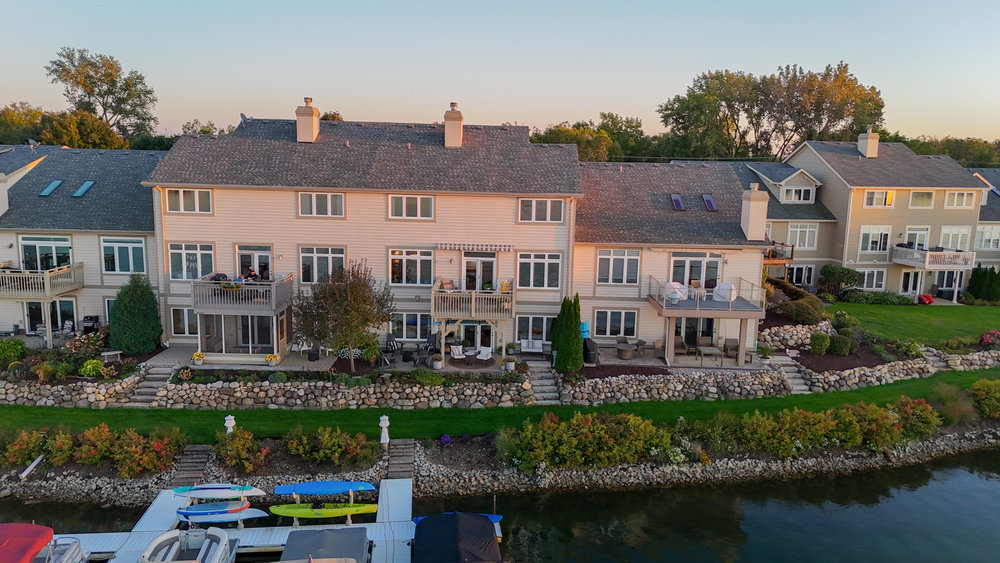 an aerial view of a house with a garden and lake view