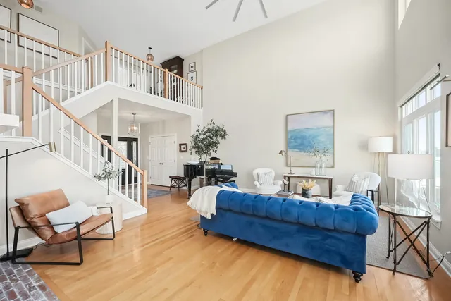 a living room with furniture and a dining table with wooden floor