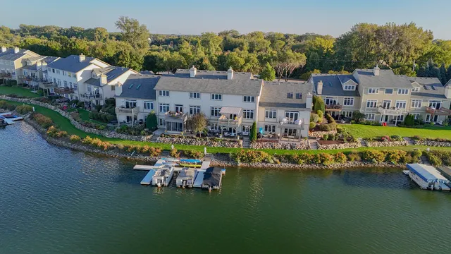 an aerial view of ocean and residential houses with outdoor space
