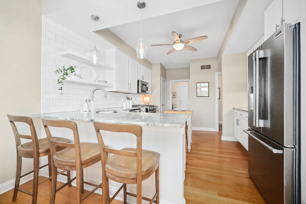 22864 Harbour Lane Plainfield, IL 60544 - Photo 10 of 65 a kitchen with stainless steel appliances granite countertop a dining table chairs refrigerator and sink