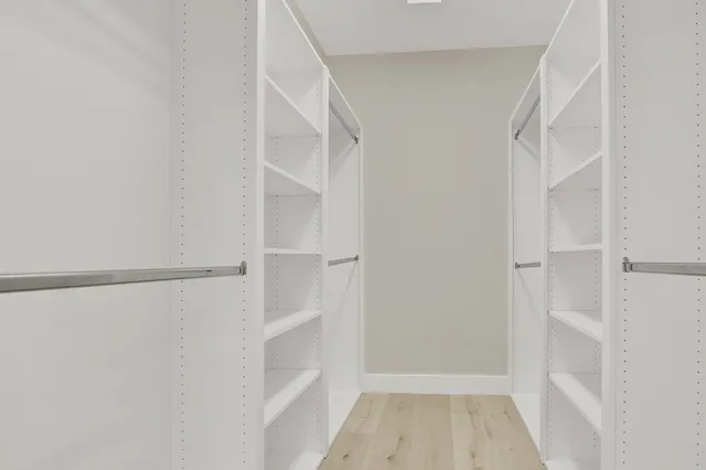 a view of walk in closet with empty racks