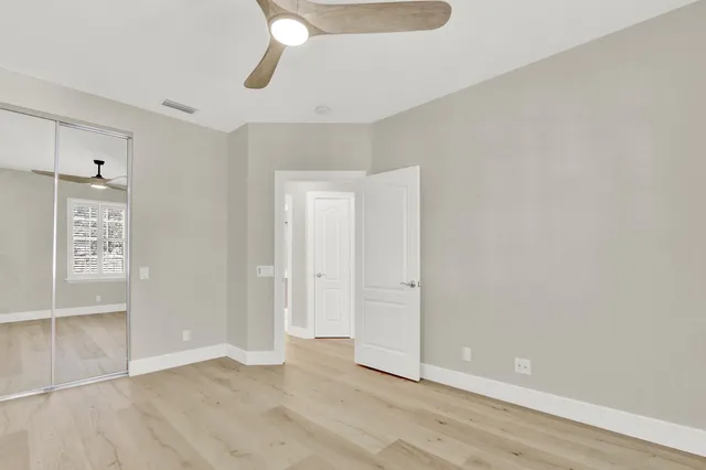 an empty room with closet and windows