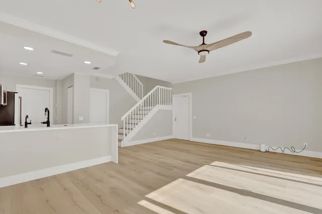 a view of a livingroom with a ceiling fan and wooden floor