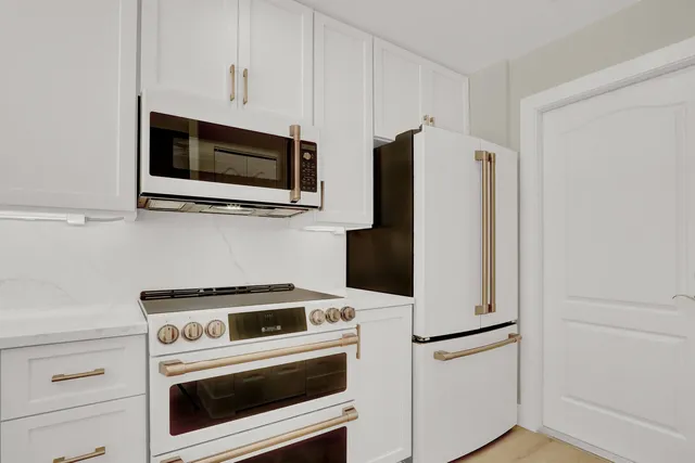 a kitchen with white cabinets and white appliances