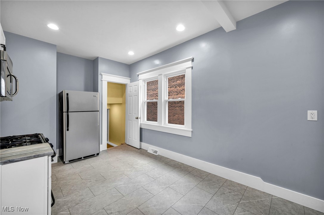 1610 Spring Road Old Brooklyn, OH 44109 - Photo 14 of 38 Kitchen with baseboards, stainless steel appliances, white cabinetry, beam ceiling, and recessed lighting