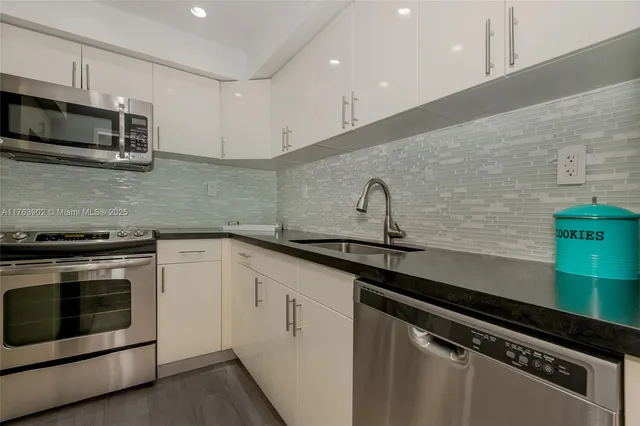 a kitchen with a sink and stainless steel appliances