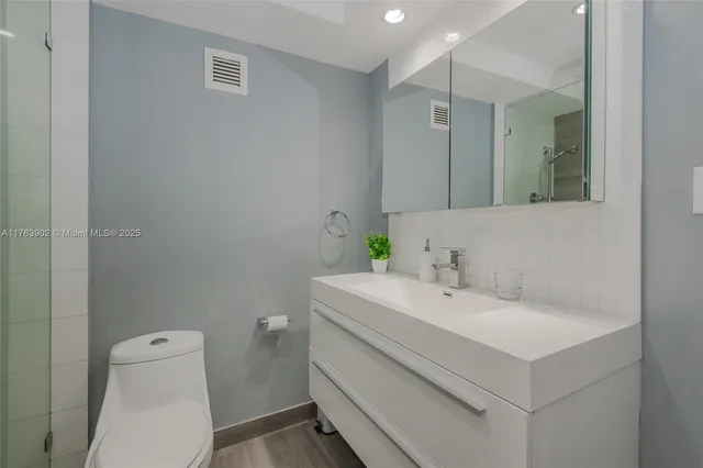 a bathroom with a sink toilet and a mirror