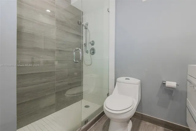 a bathroom with a toilet and a shower