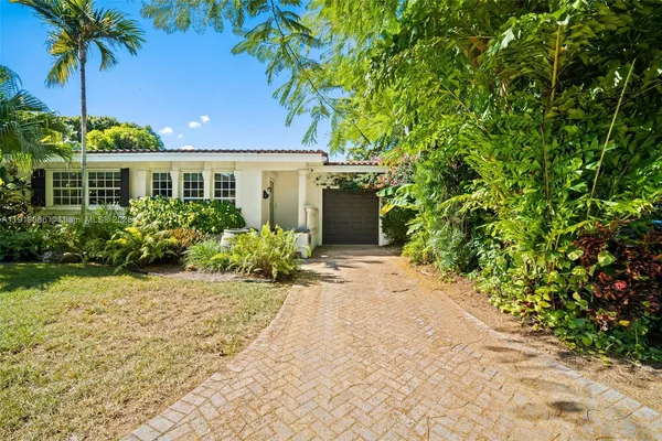 a front view of a house with a garden