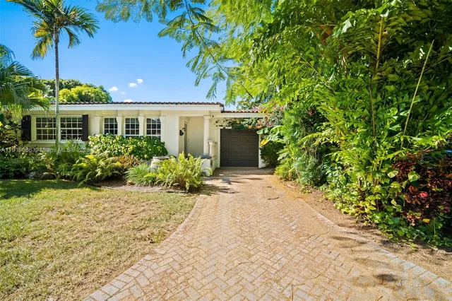 a front view of a house with a garden