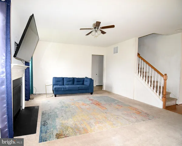 a view of a livingroom with wooden floor and staircase