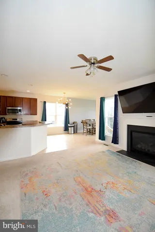 a view of a livingroom with a kitchen and a stove top oven with wooden floor
